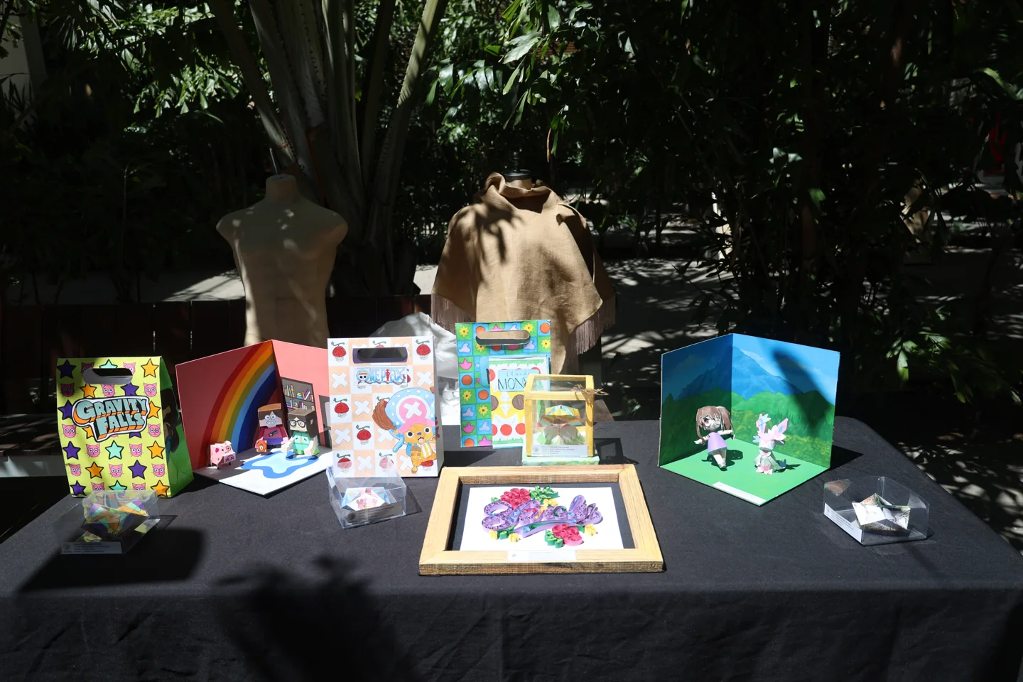 Mesa de exposición CEIBA con empaques, ilustraciones y piezas de diseño