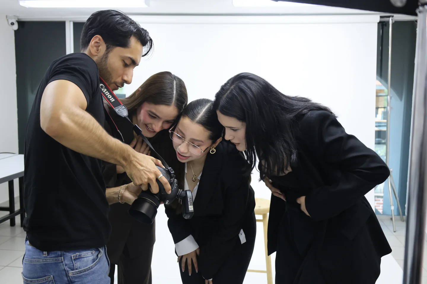 Participantes revisan una cámara durante una práctica de fotografía en UCB
