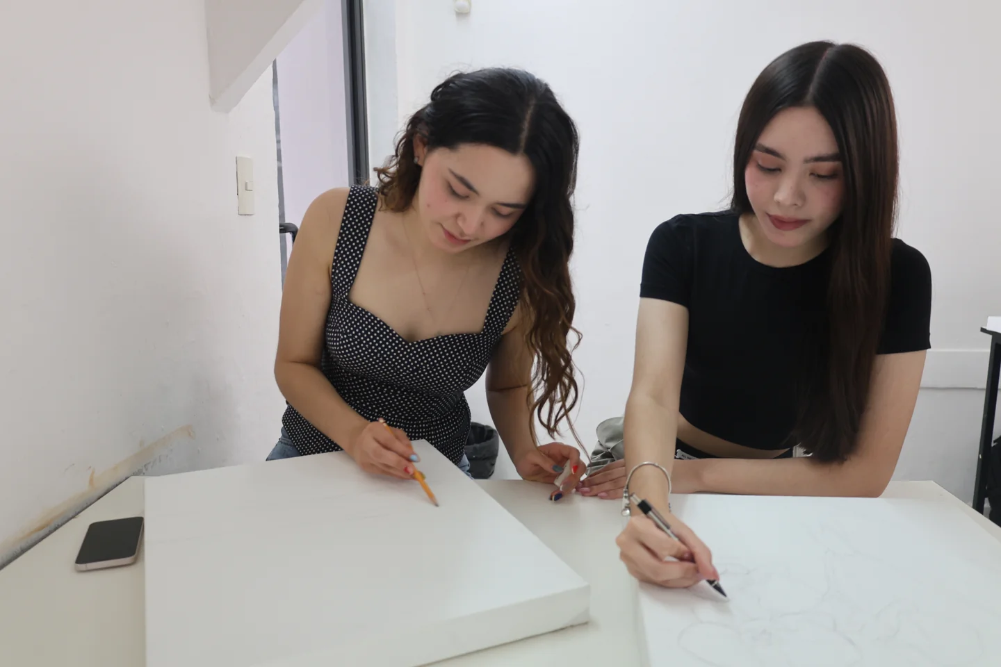 Estudiantes trabajan juntas en bocetos en el aula