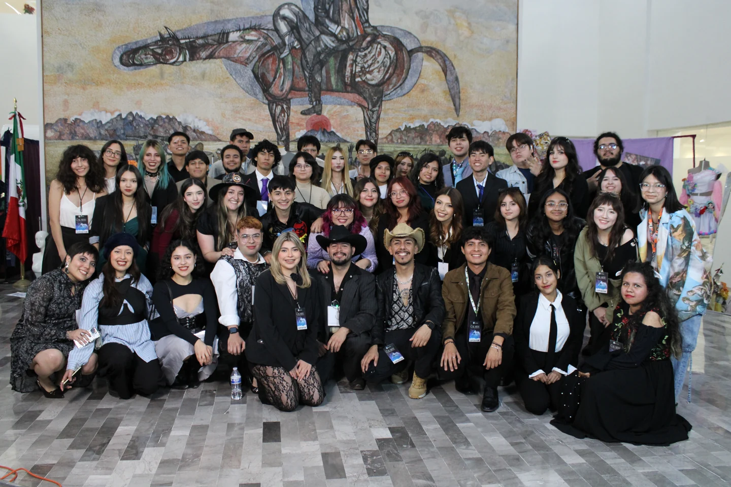 Grupo de nuestra comunidad reunido frente a un mural