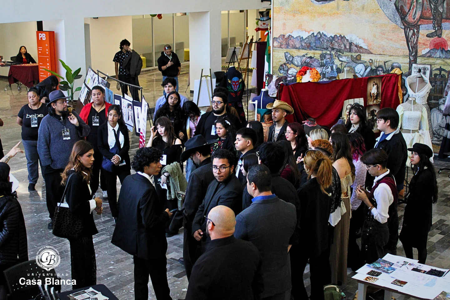 Grupo de visitantes reunido entre paneles y mesas de exhibición